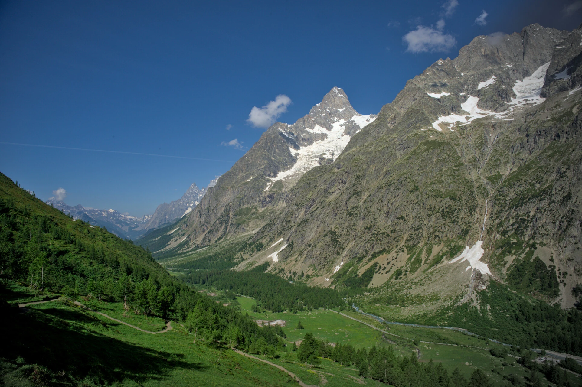 Fäbodvallarna i det italienska Val Ferret på morgonen, mellan lärkar och snötäckta toppar