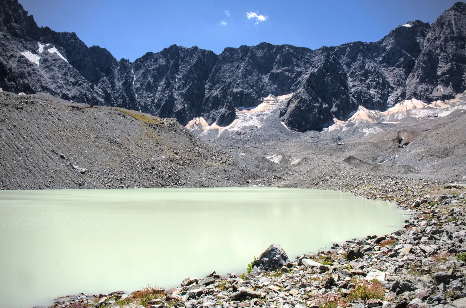 Lac du Glacier d'Arsine och dess mjölkvita vatten, omgivet av moräner och klippväggar