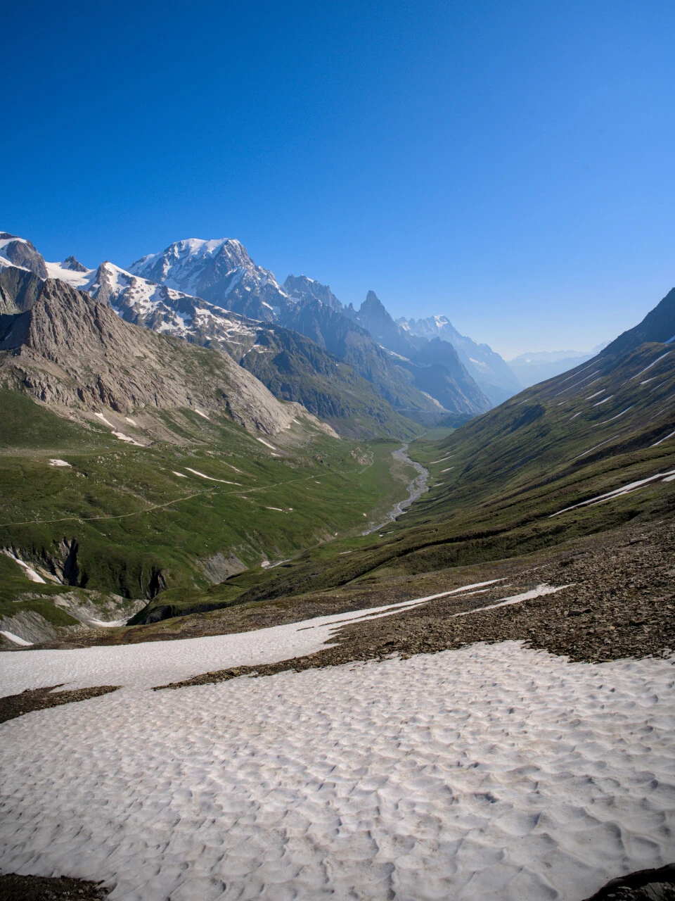 Val Veni under sommarhimmel, snöfläckar på Mont Blanc-massivets sluttningar